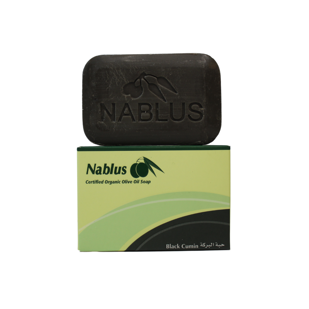 Black cumin and olive oil soap bar, the soap bar is sitting on top of its packaging, showcasing the name nablus soap company certified organic olive oil soap bar