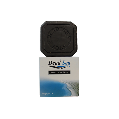 Dead Sea Black Mud Soap made with Olive Oil by Nablus Soap Company, the soap is standing on top of its box with the dead sea on it. 