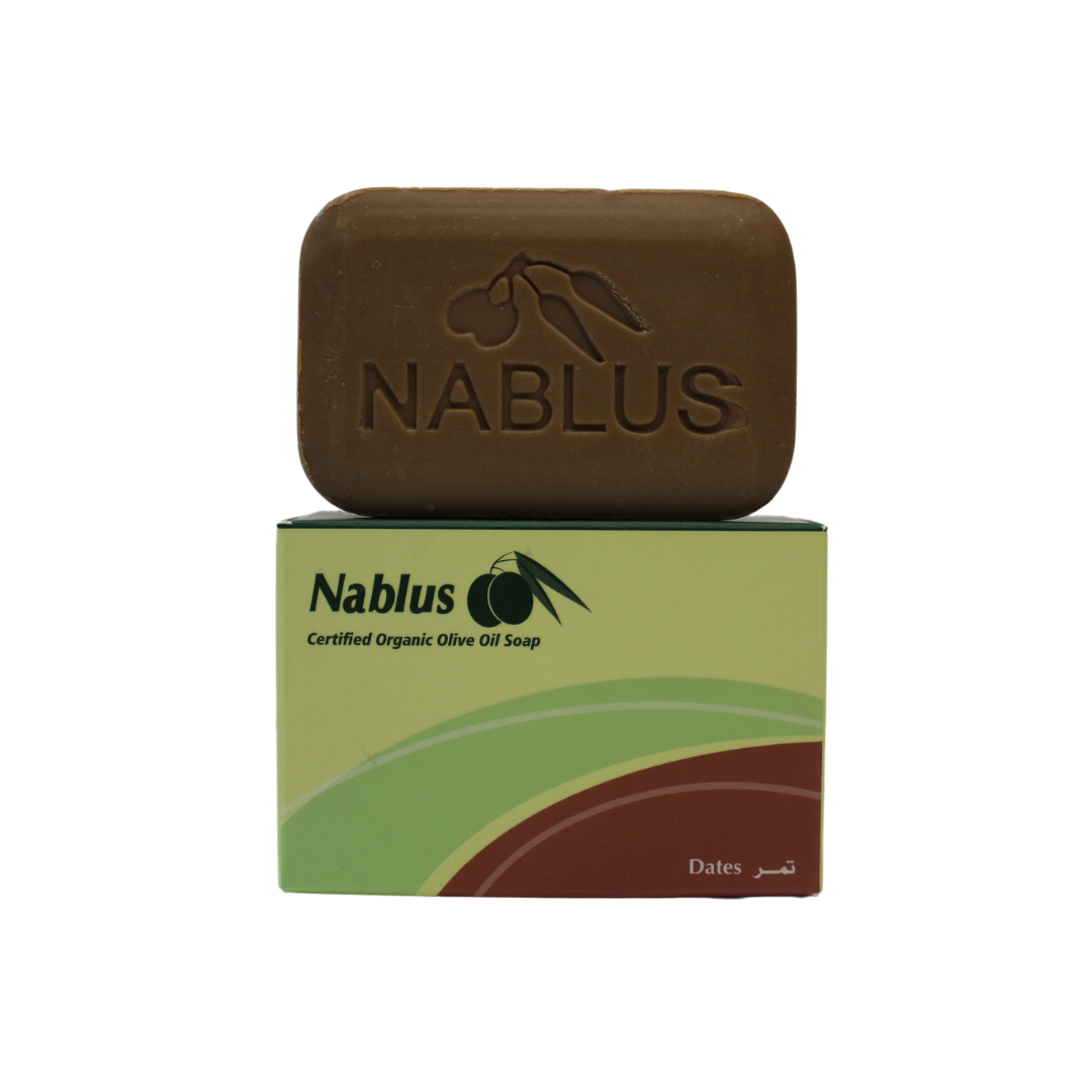 dates and olive oil soap bar made by nablus soap company. The brown soap bar is standing on its packaging reading nablus certified organic olive oil soap