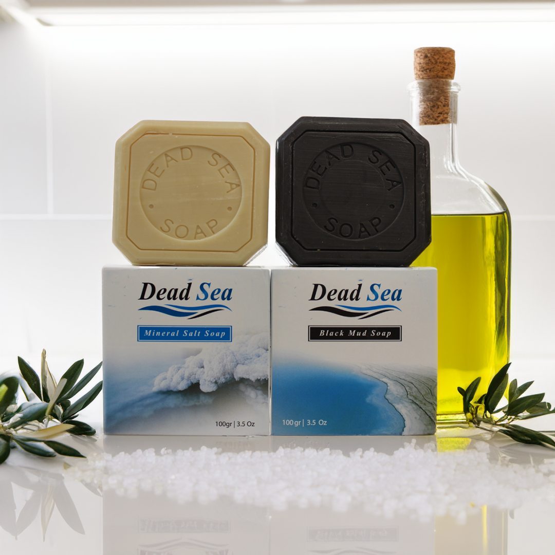 dead sea mud and dead sea salt and olive oil soap bars standing on top of their packaging made by nablus soap company with dead sea salt olive branches and olive oil around it