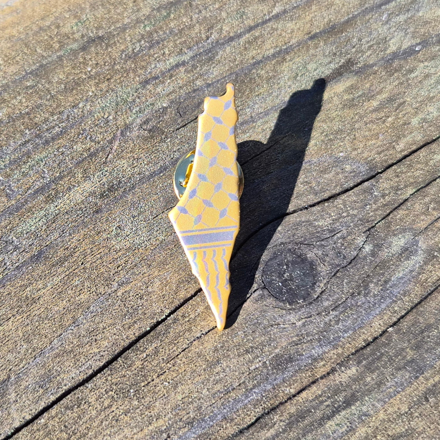 gold keffiyah pin palestine map on wooden background 