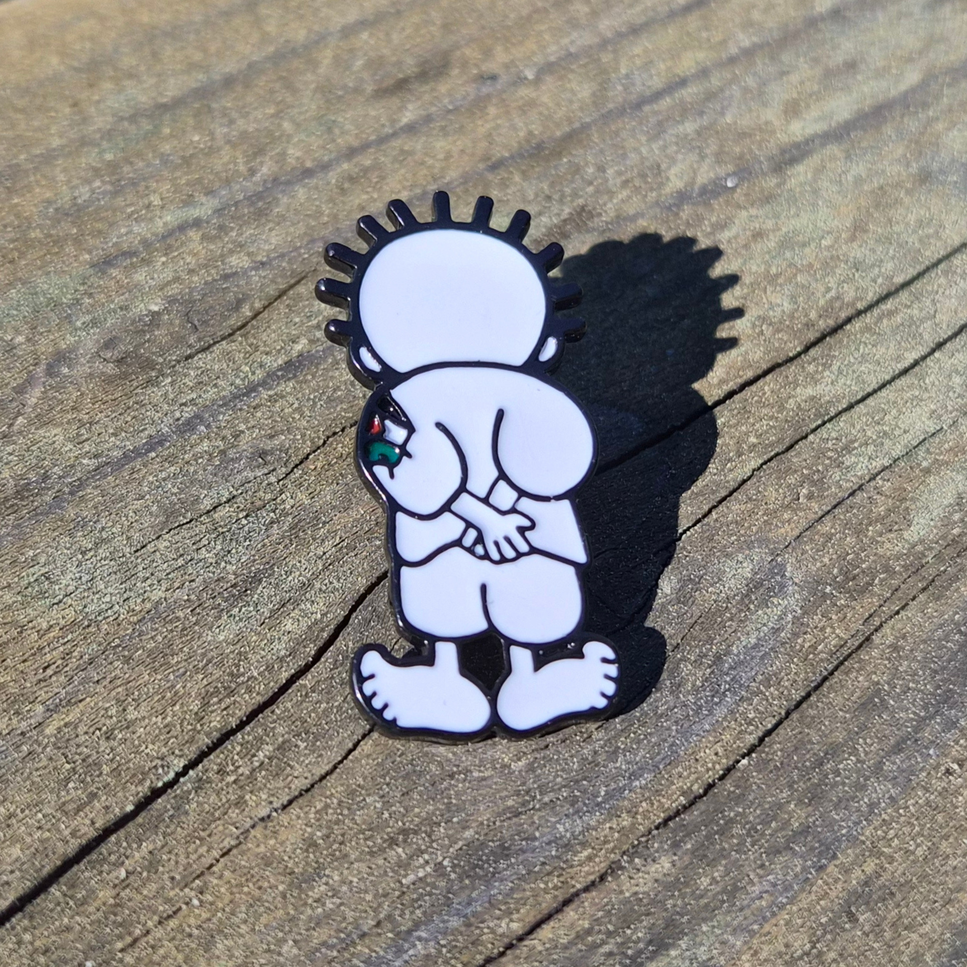 handala enamel pin on wooden background